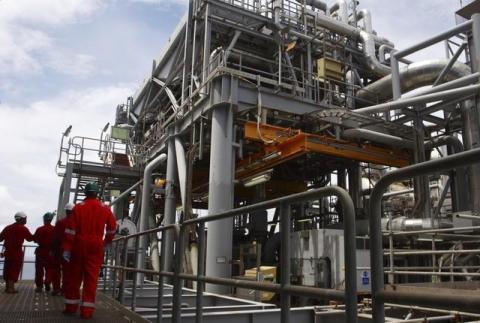 Oil workers walk through pipe installations on a tanker at Bonga off-shore oil field outside Lagos. PHOTO BY REUTERS/Akintunde Akinleye