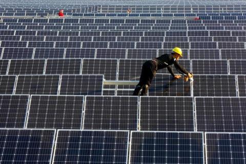 A man works on solar panels at a solar power plant of China Huaneng Group in Huaiyin, Jiangsu province, China, June 13, 2018. PHOTO BY REUTERS/Stringer
