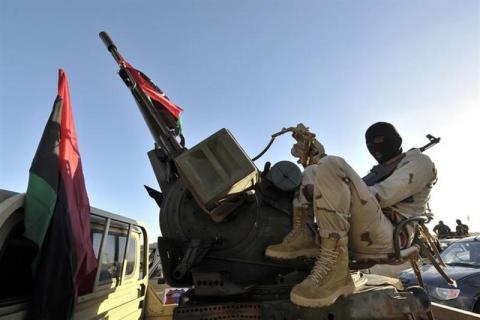 A member of the Libyan army's Thunderbolt Brigade sits at the back of a vehicle