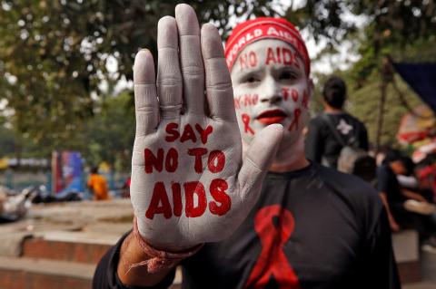 A man poses as he displays his hand and face painted with messages during an HIV/AIDS awareness campaign on the eve of World AIDS Day in Kolkata, India, November 30, 2018. PHOTO BY REUTERS/Rupak De Chowdhuri