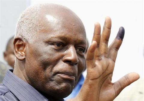 Angola's President Jose Eduardo dos Santos shows off his inked finger to photographers after casting his vote during national elections