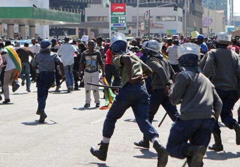 Anti-riot police chase after protesters during a march against President Robert Mugabe's government's handling of the economy in Harare, Zimbabwe, August 3, 2016. PHOTO BY REUTERS/Philimon Bulawayo