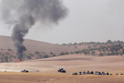 Turkish army tanks and Turkish-backed Syrian fighters make their way in the Syrian border town of Jarablus as it is pictured from the Turkish town of Karkamis, in the southeastern Gaziantep province, Turkey, August 24, 2016. PHOTO BY REUTERS/Stringer