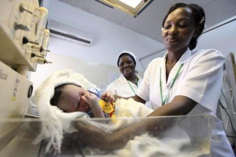 A nurse weighs a baby at the Maitama district hospital in Nigeria's capital Abuja May 22, 2011. REUTERS/Akintunde Akinleye