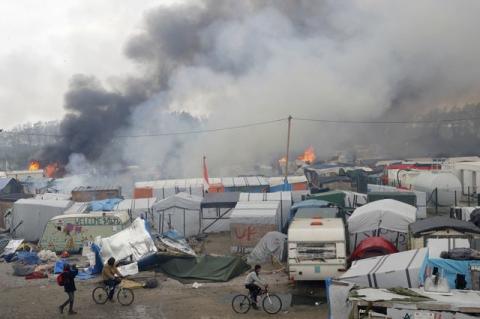 Smoke rises the sky as makeshift shelters and tents burn in the "Jungle" on the third day of the evacuation of migrants and their transfer to reception centers in France, as part of the dismantlement of the camp in Calais, France, October 26, 2016. PHOTO BY REUTERS/Philippe Wojazer