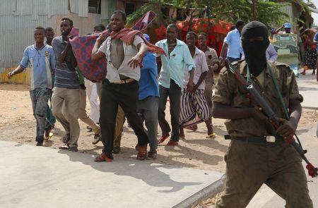 Somali people carry the dead body of a victim from the scene of a suicide car explosion in Hodan district in the capital Mogadishu, June 24, 2015. PHOTO BY REUTERS/Feisal Omar