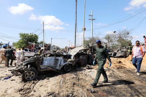 A Somali police officer walks past a wreckage at the scene of a car bomb explosion at a checkpoint in Mogadishu, Somalia, December 28, 2019. PHOTO BY REUTERS/Feisal Omar