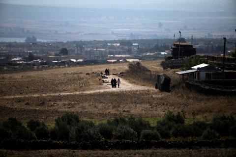 People walk near the Israel-Syria border line as it is seen from the Israeli-occupied Golan Heights, Israel, July 7, 2018. PHOTO BY REUTERS/Ronen Zvulun
