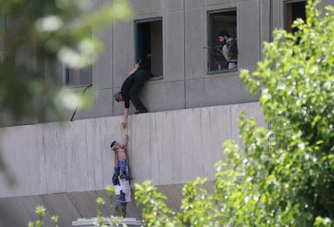 A boy is evacuated during an attack on the Iranian parliament in central Tehran, Iran, June 7, 2017. PHOTO BY REUTERS/Omid Vahabzadeh/TIMA