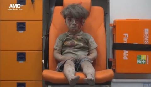 A still image taken on August 18, 2016 from a video posted on social media said to be shot in Aleppo on August 17, 2016, shows a boy with bloodied face sitting in an ambulance, after an airstrike, Syria. PHOTO BY REUTERS/Social Media