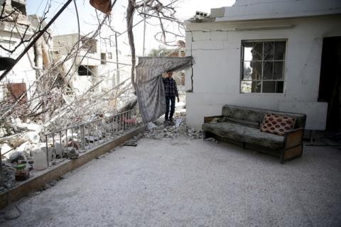 A boy inspects a damaged house in the rebel-held besieged city of Douma, a suburb of Damascus, Syria, February 27, 2016. PHOTO BY REUTERS/Bassam Khabieh