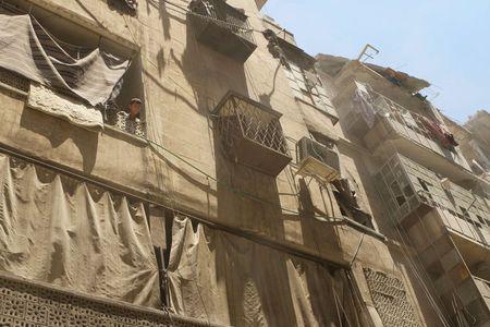 A boy stands on a balcony at a site hit by what activists said was a barrel bomb dropped by forces loyal to Syria's President Bashar al-Assad in al-Kalaseh neighbourhood of Aleppo, Syria June 21, 2015. PHOTO BY REUTERS/Abdalrhman Ismail