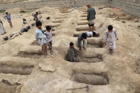 Boys inspect graves prepared for victims of Thursday's air strike in Saada province, Yemen, August 10, 2018. PHOTO BY REUTERS/Naif Rahma