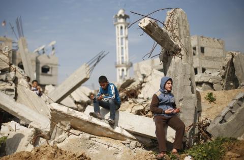 Palestinian boys attend Friday prayers as they sit at the remains of a house that witnesses said was destroyed by Israeli shelling during a 50-day war last summer, in the Shejaia neighbourhood east of Gaza City, January 23, 2015. PHOTO BY REUTERS/Suhaib Salem