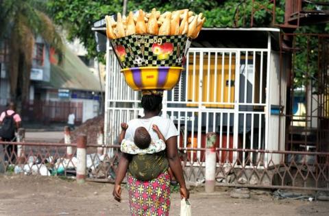A vendor carries her child on her back as she sells bread along the streets of Democratic Republic of Congo's capital Kinshasa, December 19, 2016. PHOTO BY REUTERS/Thomas Mukoya