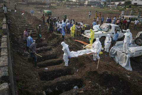 Health workers carry the body of an Ebola victim for burial at a cemetery in Freetown, December 17, 2014. PHOTO BY REUTERS/Baz Ratner