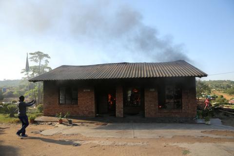 A man uses a cellphone to take pictures of a burning school office in Mashau Dolly village, in South Africa's Limpopo province, May 5, 2016. PHOTO BY REUTERS/Siphiwe Sibeko