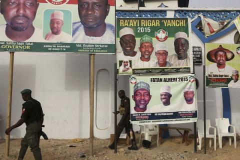 Policemen walk in front of posters of candidates of Nigeria's President Goodluck Jonathan People's Democratic Party in Kano, March 26, 2015. PHOTO BY REUTERS/Goran Tomasevic
