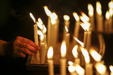 A woman places a candle after a candlelight vigil for the passengers of the missing Malaysia Airlines MH370 in central Kuala Lumpur