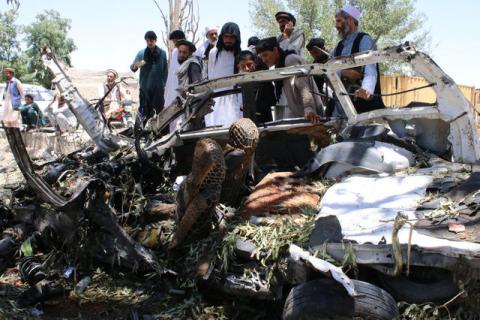 Afghan men inspect a car damaged in a suicide car bomb attack in Khost province, Afghanistan, May 27, 2017. PHOTO BY REUTERS/Stringer