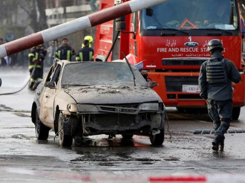 Police officers keep watch while a man drives his heavily damaged car at a car bomb attack site in Kabul, Afghanistan, January 27, 2018. PHOTO BY REUTERS/Omar Sobhani
