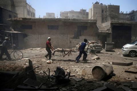 Men transport a casualty at a site hit by airstrikes in the rebel held Douma neighbourhood of Damascus, Syria, July 25, 2016. PHOTO BY REUTERS/Bassam Khabieh