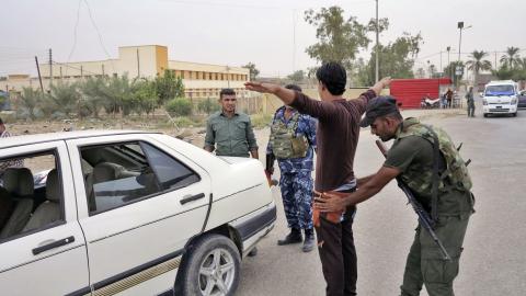 A member of the Iraqi security force searches a man at a checkpoint in Ramadi, October 12, 2014. PHOTO BY REUTERS/Stringer
