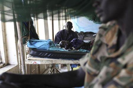 A child sick with malaria and from malnutrition lies on a bed in a hospital in Bor March 15, 2014. PHOTO BY REUTERS/Andreea Campeanu