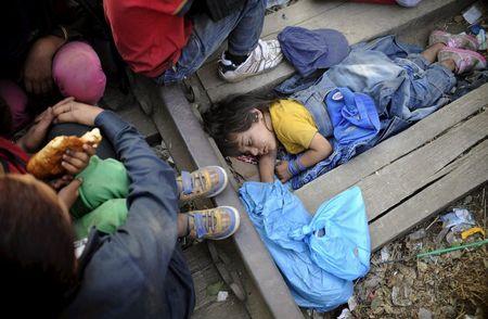 Four-year-old Rashida from Kobani, Syria, part of a new group of more than a thousand immigrants, sleeps as they wait at border line of Macedonia and Greece to enter into Macedonia near Gevgelija railway station, August 20, 2015. PHOTO BY REUTERS/Ognen Teofilovski