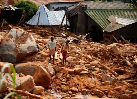 Children carry drinking water over debris created by Cyclone Idai at Peacock Growth Point in Chimanimani, on the border with Mozambique, Zimbabwe, March 22, 2019. PHOTO BY REUTERS/Philimon Bulawayo