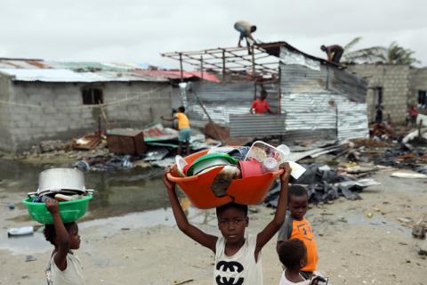 Children carry pots and plates as people repair damaged buildings in the aftermath of Cyclone Idai, in Beira, Mozambique, March 23, 2019. PHOTO BY REUTERS/Siphiwe Sibeko