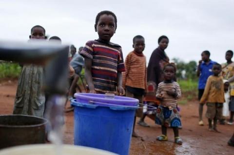 Children watch as women pump water from a borehole near Malawi's capital Lilongwe, February 2, 2016. PHOTO BY REUTERS/Mike Hutchings