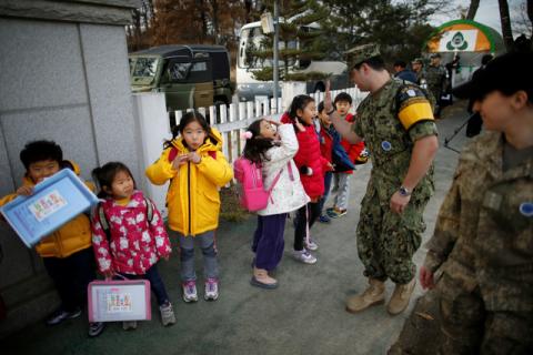 Bryan Waite, a U.S. navy officer based in JSA area for U.N. command, high-fives children at the Daesungdong Elementary School, a school inside the demilitarised zone separating the two Koreas, in Paju, South Korea. PHOTO BY REUTERS/Kim Hong-Ji