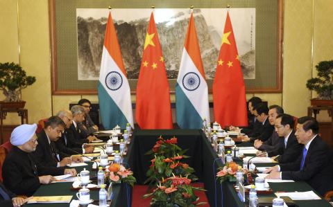 China's President Xi Jinping (R) talks with India's Prime Minister Manmohan Singh (L) during a meeting at the Diaoyutai State Guesthouse in Beijing