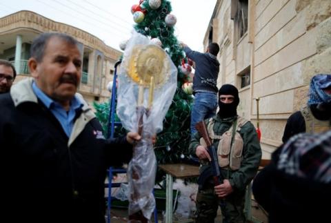Security members stand guard during a mass on Christmas Eve at the Mar Shemoni church in the town of Bartella east of Mosul, December 24, 2016. PHOTO BY REUTERS/Ammar Awad
