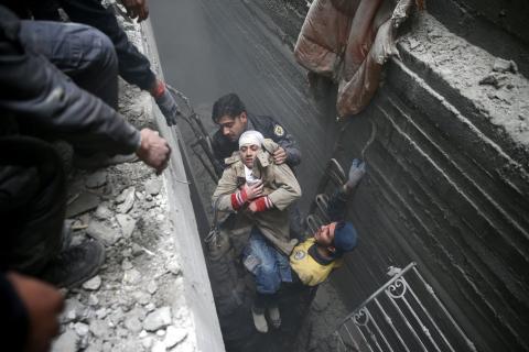Syria Civil Defence members help an unconscious woman from a shelter in the besieged town of Douma, Eastern Ghouta, Damascus, Syria, February 22, 2018. PHOTO BY REUTERS/Bassam Khabieh