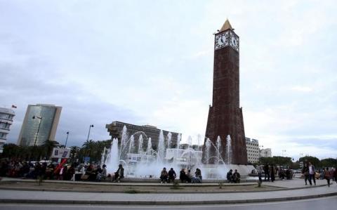 People sit in front of the clock tower at the end of Avenue Habib Bourguiba in Tunis, Tunisia, February 13, 2016. PHOTO BY REUTERS/Zoubeir Souissi