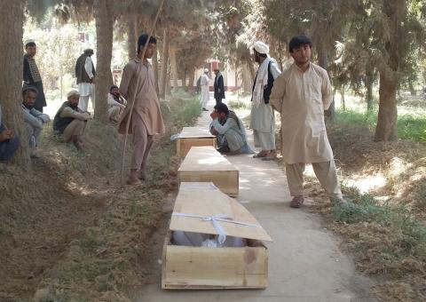 Relatives mourn next to the coffins of policemen who were killed after a Taliban attack on a military outpost in Baghlan province, Afghanistan, August 15, 2018. PHOTO BY REUTERS/Stringer
