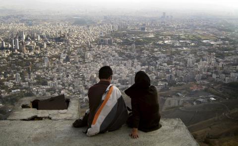 An Iranian couple sit overlooking the city of Tehran, October 19, 2006. PHOTO BY REUTERS/Morteza Nikoubazl