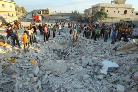 Residents inspect a site damaged by an airstrike in Hafsarja, in the insurgent stronghold of Idlib province, Syria, May 9, 2016. PHOTO BY REUTERS/Ammar Abdullah