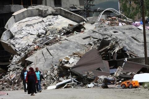 Residents walk past buildings which were damaged during security operations and clashes between Turkish security forces and Kurdish militants, in Yuksekova in the southeastern Hakkari province, Turkey, May 30, 2016. REUTERS/Sertac Kayar