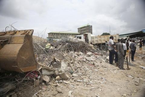 Rescue workers stand by an excavator at the site of a collapsed building at the Synagogue Church of All Nations in the Ikotun-Egbe neighbourhood of Nigeria's commercial capital Lagos, September 17, 2014. PHOTO BY REUTERS/Akintunde Akinleye