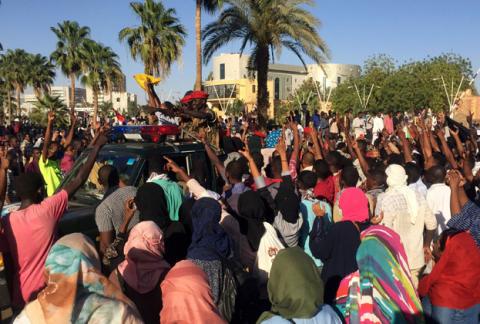 Sudanese demonstrators flash the victory sign as a military police vehicle drives past them during a protest demanding Sudanese President Omar Al-Bashir to step down in Khartoum, Sudan, April 6, 2019. PHOTO BY REUTERS/Stringer