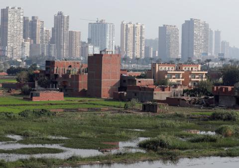 A view of houses and farmland on an island on the River Nile in front of high-rise buildings in Cairo, Egypt, November 25, 2018. PHOTO BY REUTERS/Amr Abdallah Dalsh