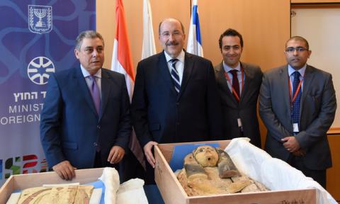 Egypt's Ambassador to Israel Hazem Khairat (L) and Dore Gold (2nd-L), director-general of Israel's foreign ministry, pose with Egyptian diplomats in front of ancient sarcophagi covers, which Israel handed back to Egypt, in Jerusalem, May 22, 2016. PHOTO BY REUTERS/Israeli Foreign Ministry