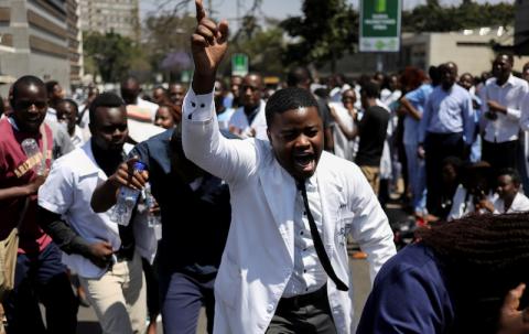 Doctors sing and hold placards during a protest over the disappearance of the leader of their union. PHOTO BY REUTERS/Siphiwe Sibeko