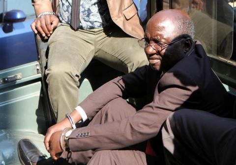 Douglas Mahiya, information secretary of the Zimbabwe National Liberation War Veterans Association (ZNLWVA) is escorted by detectives as he arrives at the Harare Magistrates' court, July 29, 2016. PHOTO BY REUTERS/Philimon Bulawayo