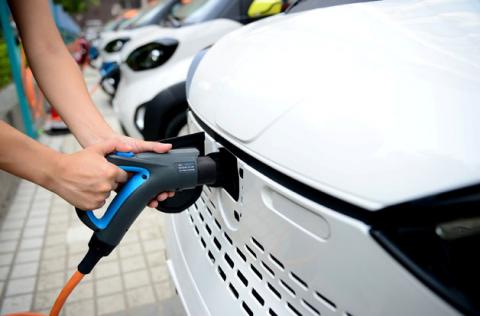 A staff member hooks up a charging cable to an electric vehicle (EV) at a charging station in Liuzhou, Guangxi Zhuang Autonomous Region, China, July 31, 2017. PHOTO BY REUTERS/Stringer