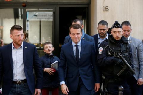 Emmanuel Macron (C), head of the political movement En Marche !, or Onwards !, and candidate for the 2017 French presidential election, leaves his home surrounded by policemen in Paris, France, April 24, 2017. PHOTO BY REUTERS/Benoit Tessier