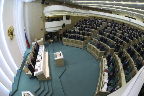 Members of the Federation Council, Russia's upper house of parliament, stand before a session in Moscow